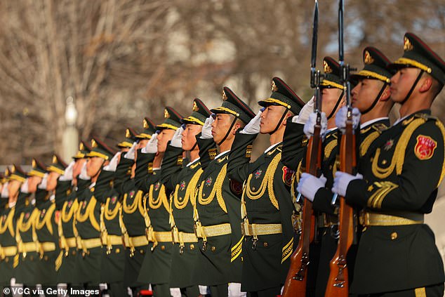 China is working on advanced brain warfare technology which is said to include devices that send enemies to sleep. Pictured: Chinese honour guards salute