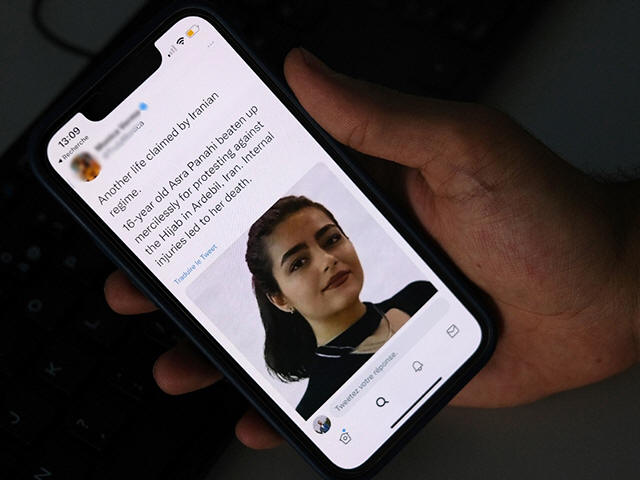 A person in Cairo looks on October 20, 2022 at a tweet about the reported death of 15-year-old Iranian girl Asra Panahi. - The 15-year-old Iranian girl died last week after being beaten during a raid by the security forces on her school, a teachers' union said, urging the authorities K