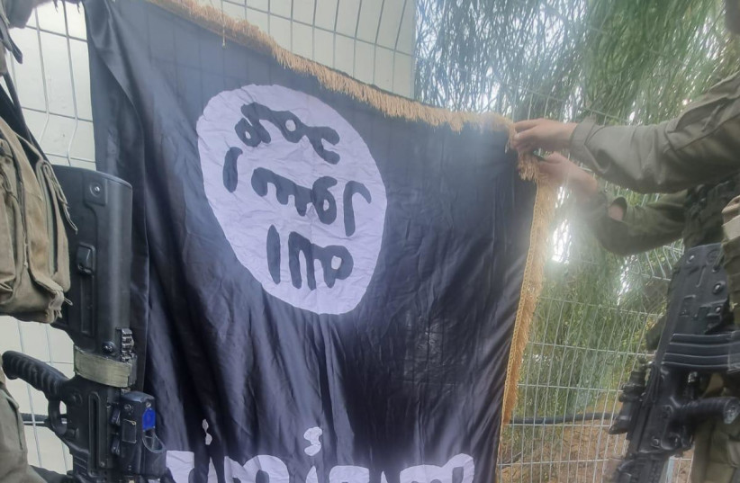  An ISIS flag seen at Israel's kibbutz Sufa following a massacre by infiltarting Hamas terrorists, pictured on October 11, 2023 (credit: IDF SPOKESPERSON'S UNIT)