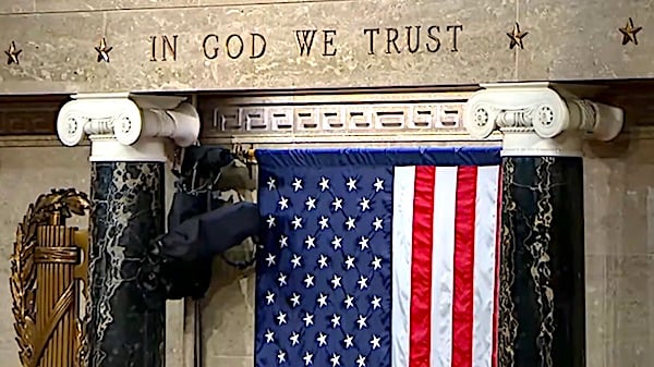 'In God We Trust' is emblazoned above the American flag in the U.S. House of Representatives on Wednesday, April 28, 2021. (Video screenshot)