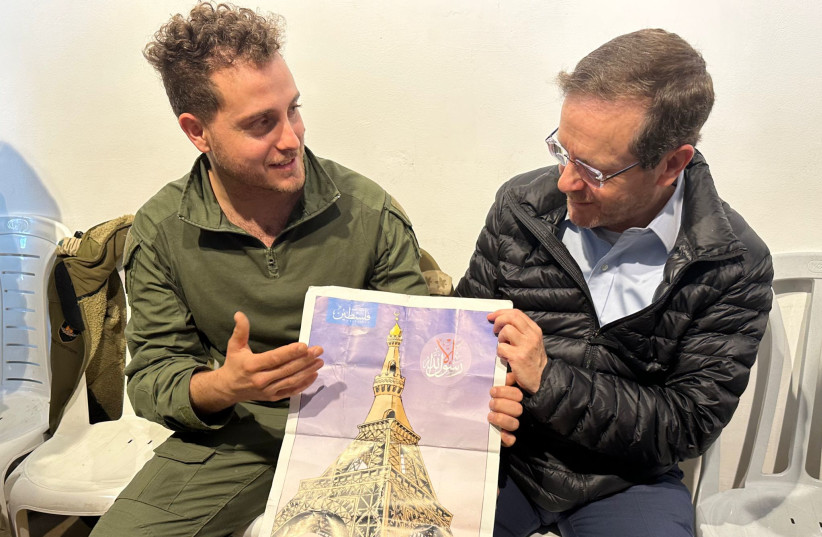  President Isaac Herzog receiving a poster found in Shejaia showing the Eiffel Tower as a mosque, January 31, 2024. (credit: GPO)