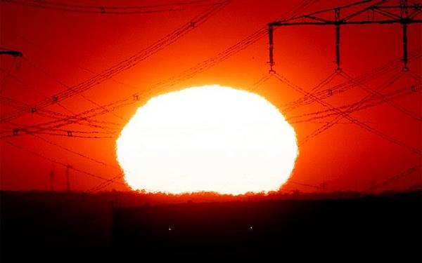 The sun rises near power lines in Frankfurt, Germany, as a heat wave scorches Europe, July 24, 2019. (AP Photo/Michael Probst)