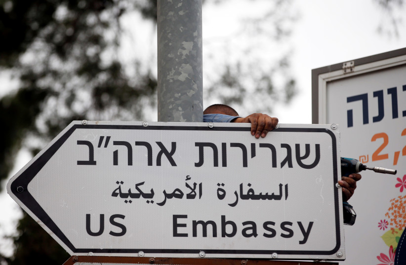 A worker hangs a road sign directing to the U.S. embassy, in the area of the U.S. consulate in Jerusalem, May 7, 2018.  (credit: REUTERS)