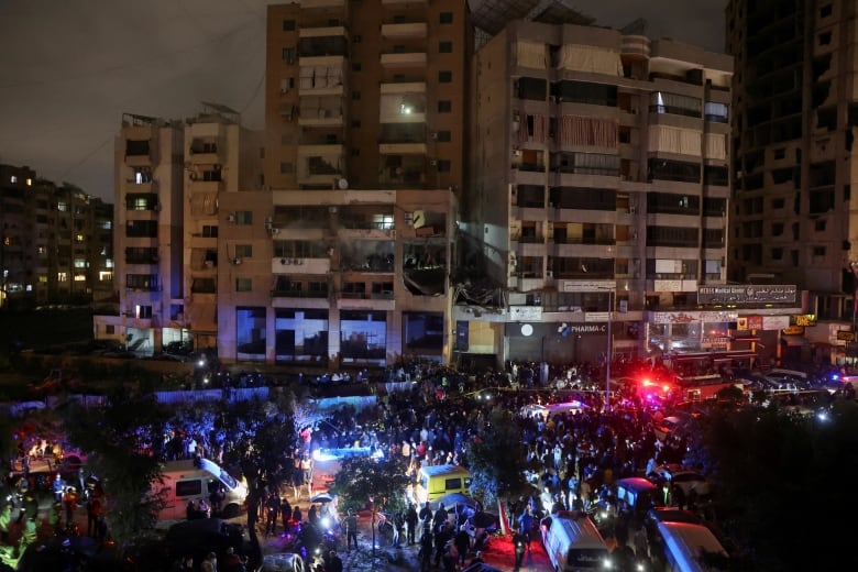 People gather near a damaged site following an explosion, in what security sources say is an Israeli drone strike, at the Beirut suburb of Dahiyeh, Lebanon January 2, 2024. 